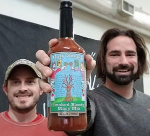 smoked bloody mary mix being held by a couple of doofuses